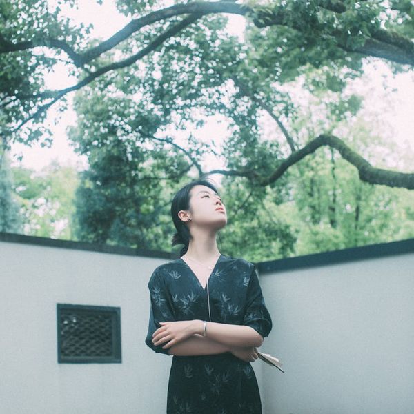 Calm person meditating in a peaceful natural setting with soft light.